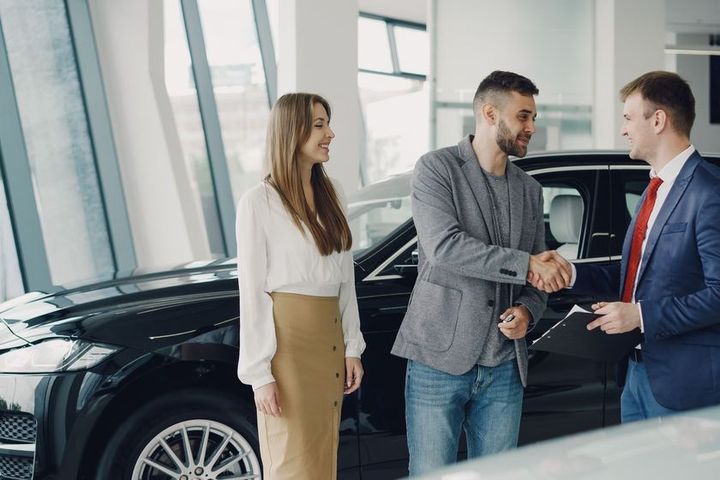 Handdruk naast een bedrijfsauto bij de dealer