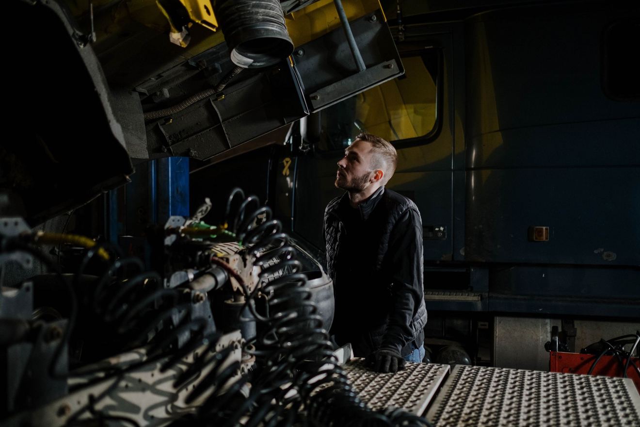 Monteur werkt onder een vrachtwagen in de eigen werkplaats